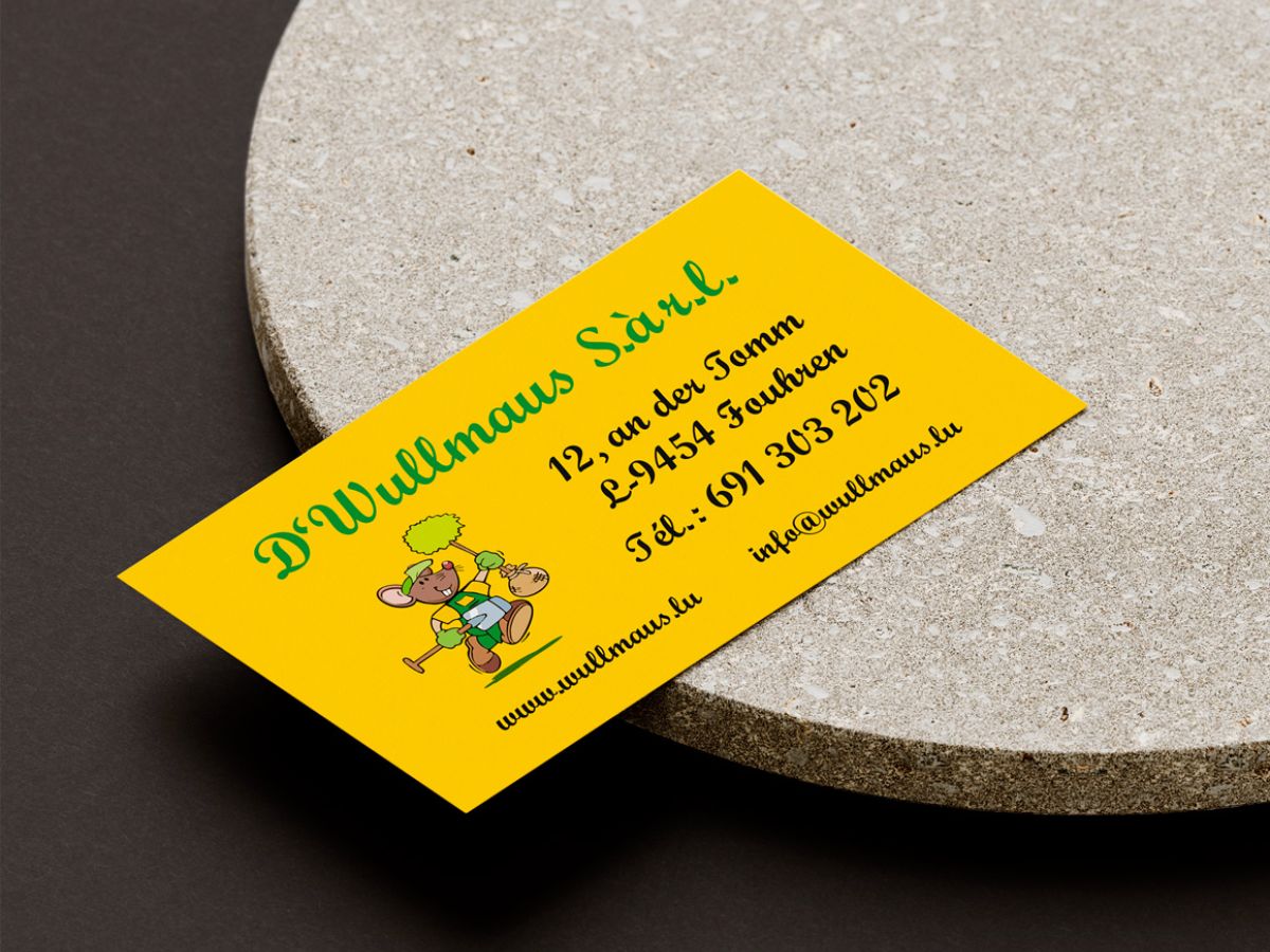 Back of the D'Wullmaus S.à r.l. business card lying on a round stone base.