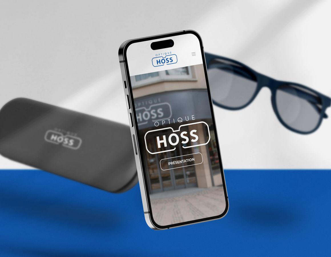 iPhone with the mobile view of the Optique Hoss website in the foreground and spectacle case with glasses in the background.