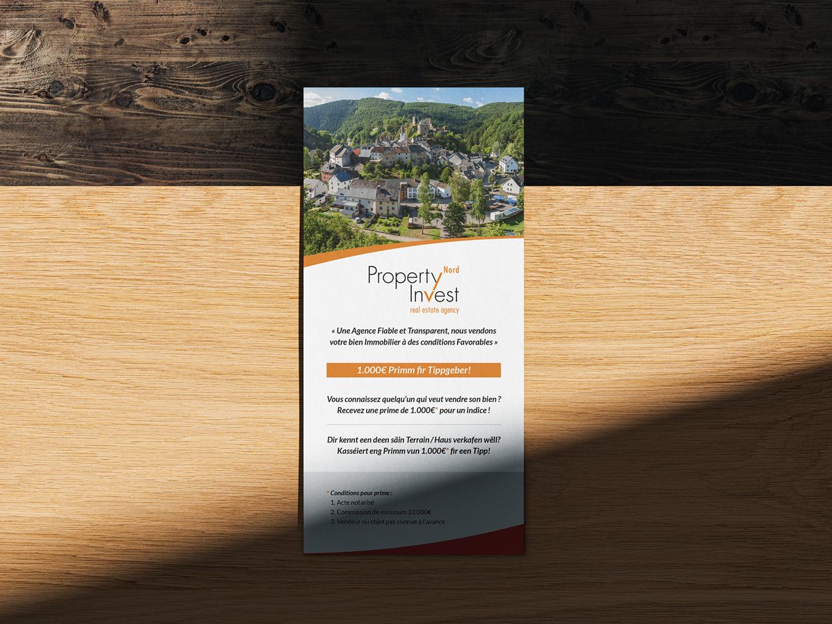 Front of the DL flyer of Property Invest Nord presented on a wooden table.