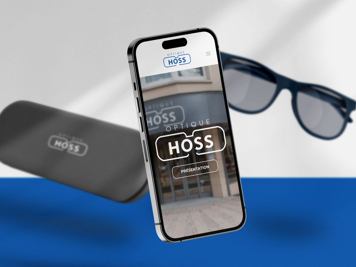 iPhone mit der mobilen Ansicht der Website von Optique Hoss im Vordergrund und Brillenetui mit Brille im Hintergrund.
